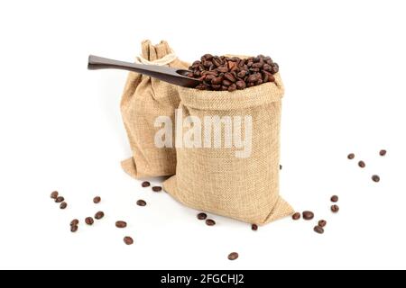 Grains de café. Deux sacs de jute avec grains de café torréfiés et spatule à café. Isolé sur fond blanc. Banque D'Images