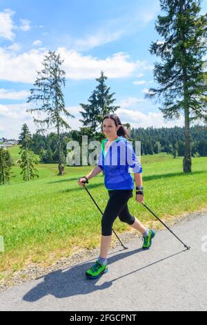 Femme faisant une marche nordique execise dans la nature idyllique dans l'été Banque D'Images