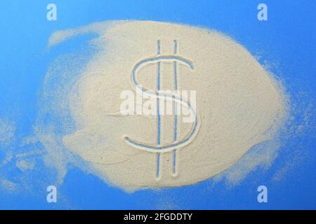 Le symbole dollar est écrit dans le sable sur un bleu arrière-plan Banque D'Images