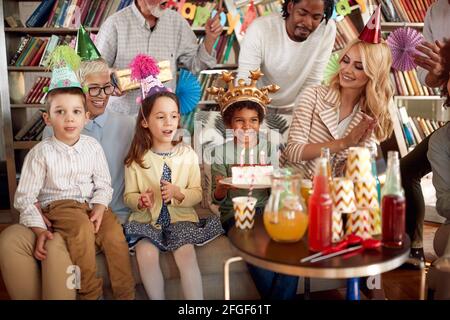 Famille et amis passer un bon moment à la fête d'anniversaire des enfants dans une atmosphère festive à la maison. Famille, célébration, ensemble Banque D'Images