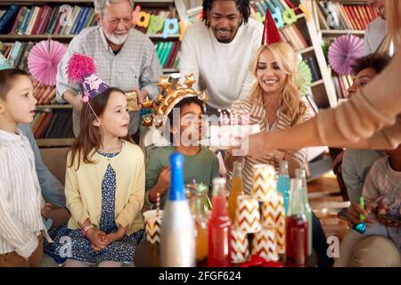 Des générations de familles célèbrent l'anniversaire de leurs enfants dans une atmosphère festive à la maison. Famille, célébration, ensemble Banque D'Images