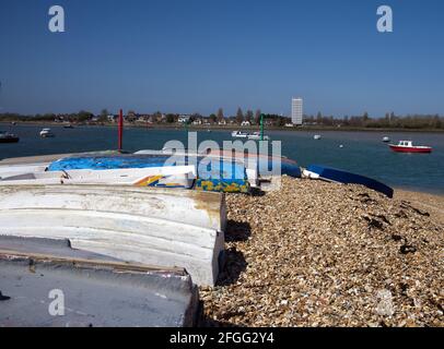 Petits bateaux colorés en plein vent sur une pointe de shingle à Eastney avec une vue sur le lac Lock, une destination de voile populaire. Banque D'Images