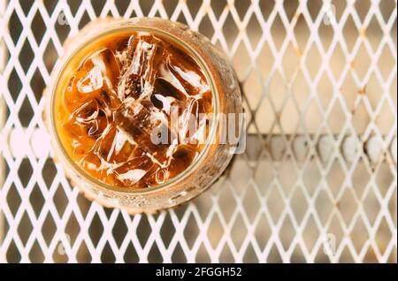 Café latte glacé dans un verre avec de la crème sur le fond. Arrière-plan de boisson d'été froide Banque D'Images