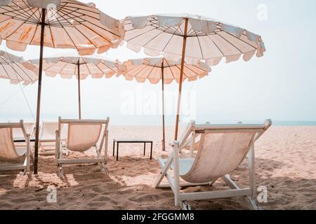 Transats et parasol blancs sur la plage tropicale. Parasol blanc sur la plage en été Banque D'Images