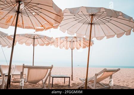 Transats et parasol blancs sur la plage tropicale. Parasol blanc sur la plage en été Banque D'Images