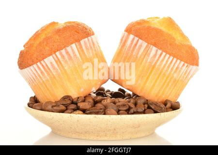 Deux petits gâteaux parfumés avec une soucoupe remplie de grains de café, gros plan, sur fond blanc. Banque D'Images