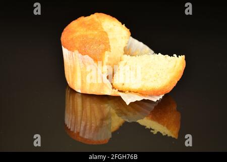 Un petit gâteau de gros plan, coupé en tranches et parfumé, sur fond noir. Banque D'Images