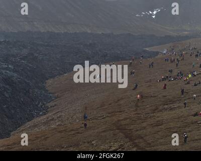 Personnes observant une éruption volcanique dans la vallée de Geldingadalir près de la montagne Fagralsfjall, Grindavík, péninsule de Reykjanes, sud-ouest de l'Islande. Banque D'Images