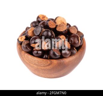 Graines de guarana dans un bol en bois, isolées sur fond blanc. Supplément alimentaire guarana, source de caféine pour boissons énergétiques. Banque D'Images