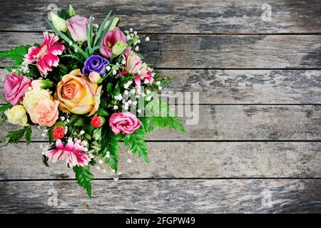 Bouquet de différentes fleurs colorées sur une vieille table en bois Banque D'Images