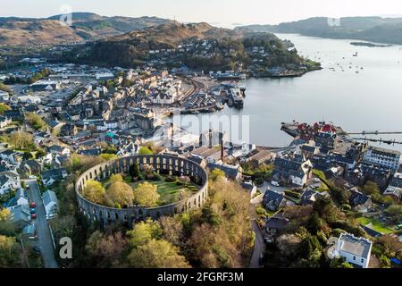 McCaig's Tower sur Battery Hill surplombant la ville d'Oban à Argyll, sur la côte ouest de l'Écosse. La folie a été commandée pour fournir des travaux pour les maçons locaux par le banquier John Stuart McCaig en 1885 et achevée en 1902 et est construite en pierre de la carrière Bonawe sur le Loch Etive. Date de la photo: Dimanche 25 avril 2021. Banque D'Images