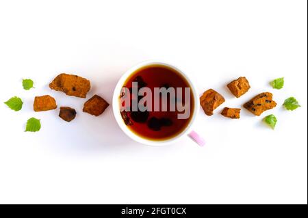 Tasse de thé de champignon chaga de bouleau et chaga écrasé morceaux de champignons pour la préparation du thé isolés sur fond blanc Banque D'Images