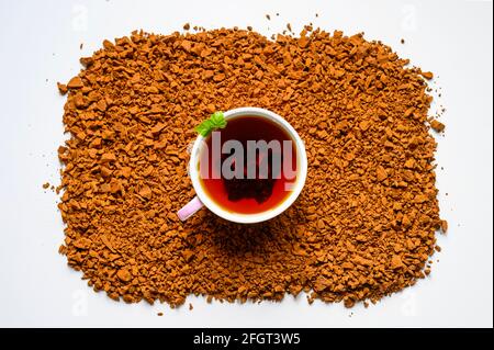 thé aux champignons de chaga. une tasse de thé infusé de chaga de champignon de bouleau sur une pile de petits morceaux cassés isolés sur fond blanc Banque D'Images