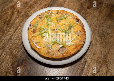 Une délicieuse saucisse cuite et une frittata de Hash Brown sur un table de cuisine en bois Banque D'Images