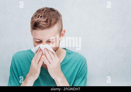 Un jeune homme est malade de la grippe. Concept de nez froid et liquide. Banque D'Images