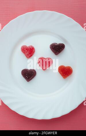 Marmelade en forme de cœur sur fond rose blanc. Concept de la Saint-Valentin. Photo verticale Banque D'Images