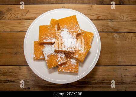 Une pile de délicieux carrés de citron, des gourmandises maison sur une table de cuisine en bois Banque D'Images