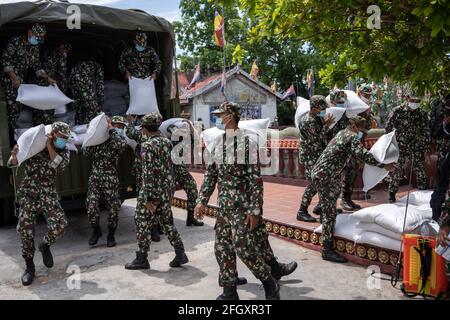Phnom Penh, Cambodge. 24 avril 2021. Les soldats de l'armée déchargent des vivres à la pagode pour les faire don aux familles vivant dans les zones rouges pendant la pandémie du coronavirus.Phnom Penh reste en confinement alors que le Cambodge prend des mesures drastiques pour réduire la propagation de sa pire épidémie de COVID-19 à ce jour. Le verrouillage a forcé de nombreuses personnes à quitter le travail, y compris les ouvriers d'usine et les vendeurs du marché, laissant les habitants les plus pauvres des villes luttant ou incapables de se permettre des nécessités de base. Crédit : Andy ball/SOPA Images/ZUMA Wire/Alay Live News Banque D'Images