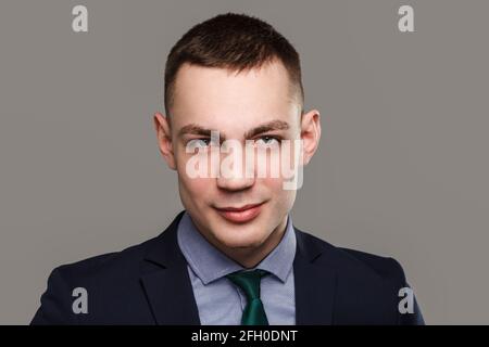 Jeune homme d'affaires sincère portrait isolé sur fond gris. Banque D'Images