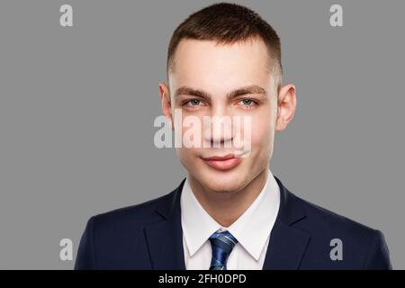 Jeune homme d'affaires sincère portrait isolé sur fond gris. Banque D'Images
