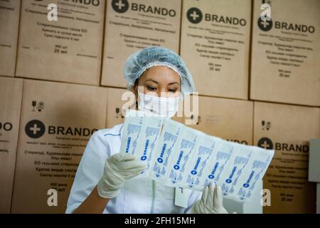 Atyrau, Kazakhstan - 21 mai 2012 : usine de production de seringues Brando. Jeune femme asiatique dans le masque de contrôle de l'emballage de la seringue. Banque D'Images