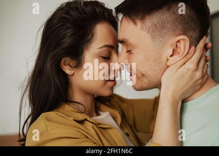 Un jeune couple heureux s'embrasse avec passion et amour, gros plan. Jeune famille déménapose dans un nouvel appartement Banque D'Images