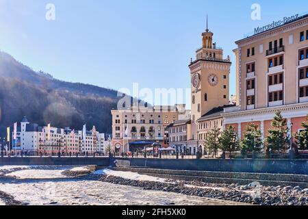 Sotchi, Russie - 4 mars 2020 : station de ski Rosa Khutor. Vue sur la rivière Mzymta et l'hôtel de ville avec horloge sur la place Rosa. Paysage urbain Banque D'Images