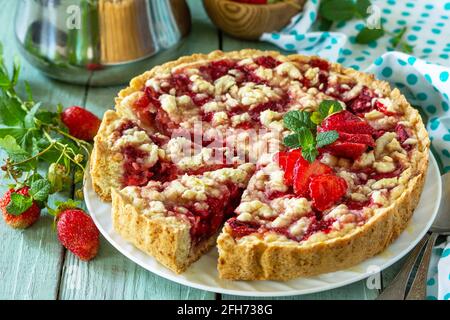 Cuisson maison. Dessert d'été. Tarte aux fraises avec chapelure et fraises fraîches sur une table rustique en bois. Banque D'Images