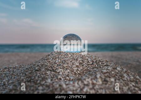 boule optique en verre sur la côte azur sablonneuse du mer Banque D'Images