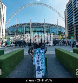 Londres, Royaume-Uni. 25 avril 2021. Un vendeur de souvenirs devant le stade Wembley pour la finale de la coupe Carabao entre Manchester City et Tottenham Hotspur. 8,000 spectateurs, dont des fans des deux équipes, des travailleurs du NHS et des résidents locaux, vont assister au match qui est un test officiel pour le programme de recherche sur les événements du gouvernement britannique. Les données seront collectées pour la gestion et la réduction de la transmission Covid-19 afin que les sites puissent se préparer à accueillir des foules et des auditoires plus nombreux lorsque les restrictions de verrouillage seront assouplies. Credit: Stephen Chung / Alamy Live News Banque D'Images