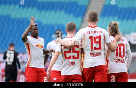 25 avril 2021, Saxe, Leipzig: Football: Bundesliga, RB Leipzig - VfB Stuttgart, Matchday 31 à Red Bull Arena: Joueurs de Leipzig, défenseur Nordi Mukiele (l), milieu de terrain Dani Olmo (m) et buteur Alexander Sörloth (2e à partir de droite) fêtez avec le buteur du 2:0, milieu de terrain Emil Forsberg (M). Conformément aux règlements du DFL Deutsche Fußball Liga et du DFB Deutscher Fußball-Bund, il est interdit d'utiliser ou d'utiliser des photos prises dans le stade et/ou du match sous forme de séquences d'images et/ou de séries de photos de type vidéo. Photo: Jan Woitas/dpa-Zentra Banque D'Images