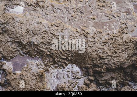 Une route de sable boueuse, glissante et baignée de pluie. Texture de la saleté de la route avec traces de roues et de patins de transport Banque D'Images