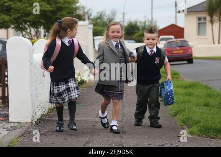 Ayrshire, Écosse, 20 août 2018. Premier jour de l'école primaire. Trois enfants dans leur nouvel uniforme scolaire Banque D'Images