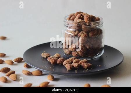 Amandes confites croquantes et dorées. Prise de vue sur fond blanc. Banque D'Images