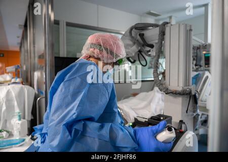 Un professionnel de la santé portant un équipement de protection individuelle (EPI) à la clinique hospitalière de Barcelone effectue une radiographie sur un patient à l'unité de soins intensifs.Barcelone est l'une des villes d'Europe qui a vu son système de santé s'effondrer le plus en raison des cas graves de Covid-19. Ici, au sein de l'unité de soins intensifs de la clinique hospitalière, la normalité revient progressivement à mesure que la pandémie est maîtrdonnée. Bien que les patients Covid les plus graves, dont la plupart ne peuvent pas respirer seuls, sont encore traités ici tandis que la pression sur le personnel de santé est en quelque sorte supportable. Espagne Santé Banque D'Images