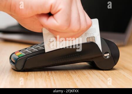 Gros plan homme main faisant glisser la carte de crédit à l'aide du terminal de PDV pour le paiement. Banque D'Images