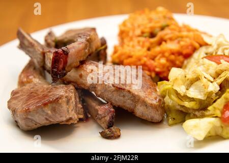 côtelettes d'agneau avec riz djuvec et salade Banque D'Images