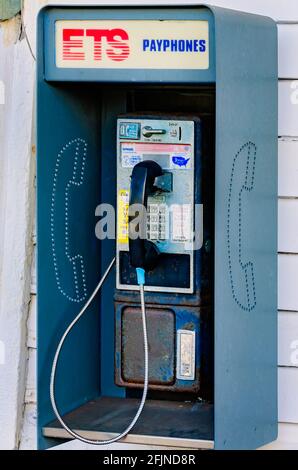 Un téléphone public à pièces, également appelé téléphone public, est accroché au mur à l'extérieur du dépôt ferroviaire de Pascagoula à Pascagoula, Mississippi. Banque D'Images