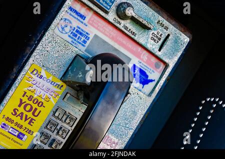 Un téléphone public à pièces, également appelé téléphone public, est accroché au mur à l'extérieur du dépôt ferroviaire de Pascagoula à Pascagoula, Mississippi. Banque D'Images