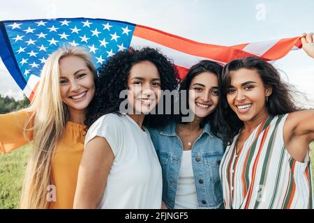 Groupe de jeunes femmes multiethniques drapeau américain Banque D'Images