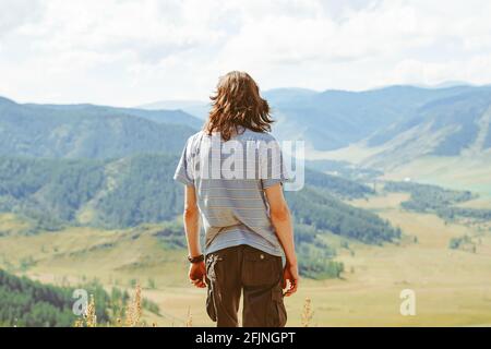 L'homme regarde autour de la colline. Guy se dresse au sommet de la montagne et jouit d'une vue panoramique sur la vallée de Kootenay, Creston, Colombie-Britannique, Canada Banque D'Images