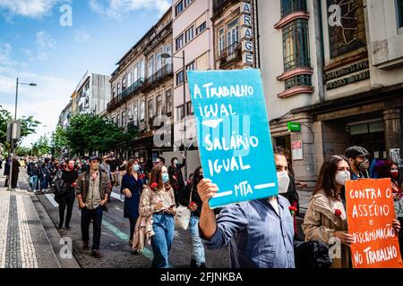 Porto, Portugal. 25 avril 2021. Un homme tient un écriteau demandant l'égalité dans le monde du travail pendant la parade. Le 25 avril est la Journée de la liberté au Portugal et à Porto, elle a été célébrée par une Parade commençant où la police politique (PIDE) d'avant 1974 a été, maintenant le Musée militaire et se terminant à la place Aliados, la place principale de la ville. Crédit : SOPA Images Limited/Alamy Live News Banque D'Images