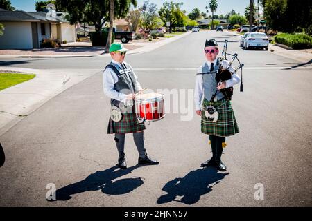 24 avril 2020, Arizona, États-Unis: Le 2-man Pipe Band, Thomas Rowley, 15, sac Pipes et Jaymes, 16, batteur, a joué dans les rues de la ville de Tempe, en Arizona, dans les premiers jours de l'enfermement. A déclaré Thomas, ''le 2 Man Pipe Band a commencé comme un moyen de divertir nos voisins le jour de la St Patrick. Il s'est ensuite transformé en spectacle autour de Tempe pour divertir les gens pendant la quarantaine. Nous avons pensé que nous pourrions rendre certaines personnes heureux, au lieu de simplement s'asseoir autour de la maison toute la journée. Nous étions occupés ! Quand le temps est devenu trop chaud, et que nous avons dû arrêter de fonctionner, nous avons mieux compris pourquoi les gens étaient si enthousiastes à l'idée de voir Banque D'Images