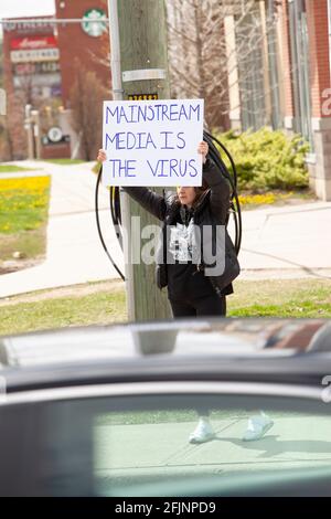 Vaughan, Canada - le 25 avril 2021 : une femme qui détient des médias traditionnels est le signe du virus en signe de protestation contre les mesures de fermeture de la COVID-19 en Ontario Banque D'Images