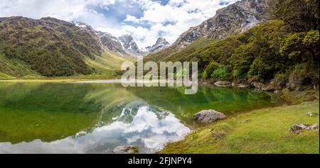 Tranquille lac de montagne Mackenzie à la célèbre Routeburn Track, parc national Fiordland, île du Sud de la Nouvelle-Zélande Banque D'Images