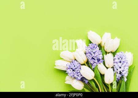 Bouquet de fleurs de printemps sur fond vert. Fête des mères, Saint-Valentin, concept de célébration d'anniversaire. Vue de dessus, espace de copie pour le texte Banque D'Images