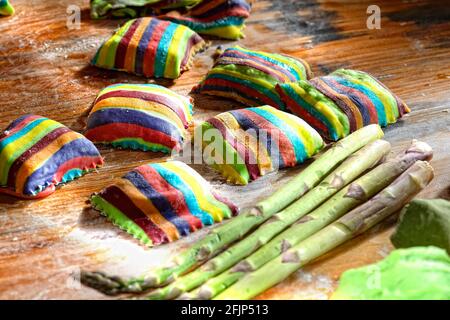 Raviolis colorés faits maison sur table en bois farinée, Allemagne Banque D'Images