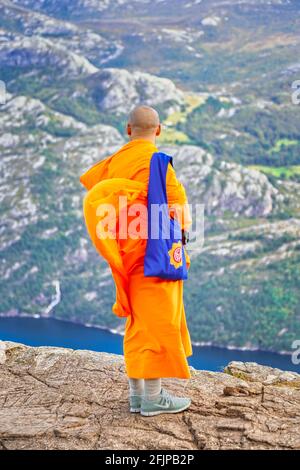 Monk parmi les touristes à Preikestolen ( le rocher de Pulpit ) à Lysefjord en Norvège. Ein Mönch mit Touristen auf dem Preikestolen am Lysefjord in Norwegen. Banque D'Images