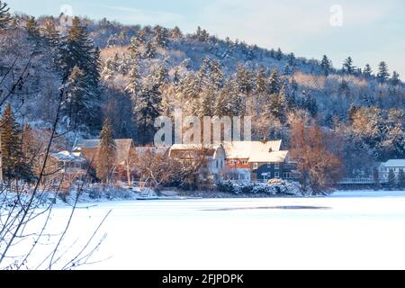 Grange rouge au milieu d'arbres enneigés sur une colline à hiver Banque D'Images