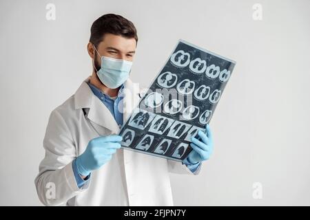 Homme souriant médecin dans le masque du visage analyse des poumons rayons X IRM afficher les bons résultats de l'acquisition Banque D'Images